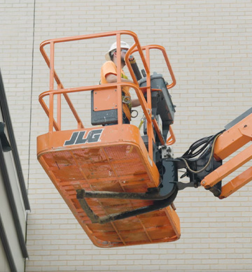 a maintenance professional uses a tablet to service a large commercial Trane HVAC unit