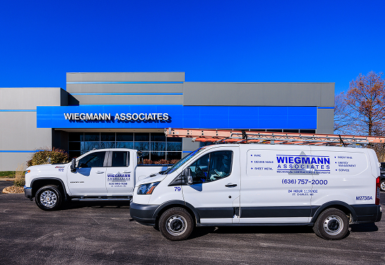 two work trucks parked in front of the Weigmann Associates office